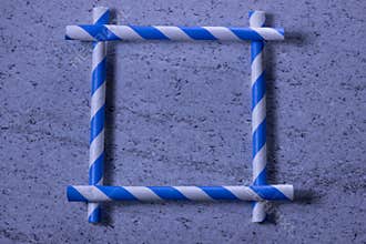 Kreatív keret kék-fehér csíkos szívószálakból, minimalista háttérrel