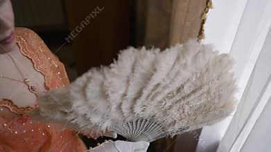 Elegant woman opening feather fan