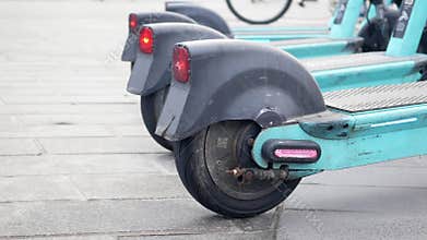 Close-up of electric scooters parked along a city walkway