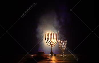Glowing Menorah with Candles and Goblet in Low Light