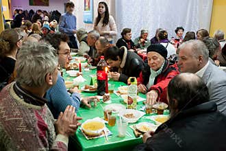Elderly women and men have a food at the Christmas charity dinner for the homeless
