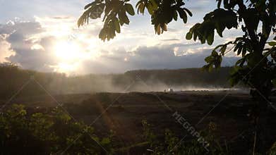 Misty Sunset Over a Rugged Landscape and car with camera paning