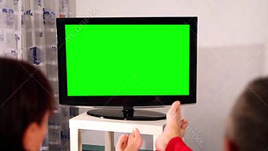 Man and woman watching television. Green screen.