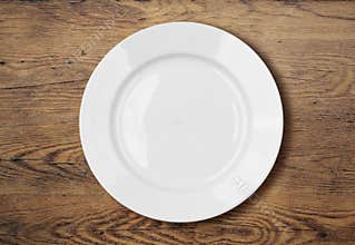 White empty dinner plate on wooden table surface