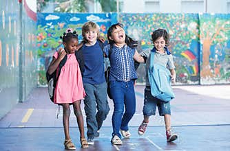 Happy kids embracing and smiling in the elementary schoolyard. I
