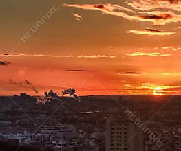 Sunset over Paris with city skyline and smoke rising in the distance