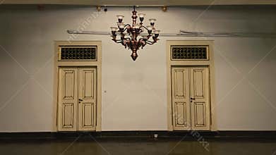 Symmetrical historic interior with chandelier and twin doors