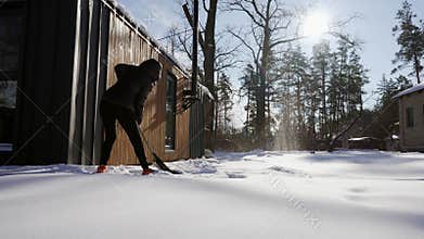 A woman near her house is shoveling snow.
