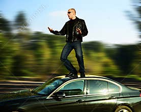 Crazy man standing on moving car