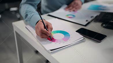 Close up male hands holding pen analyzing circle diagram with profit results datum unknown business man analyst review