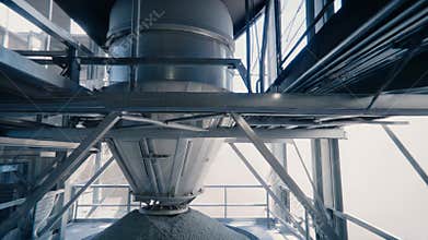 Industrial silo filling with construction materials inside factory