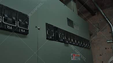 Electrician\'s Gloved Hand Turning Off Circuit Breaker in Electrical Panel