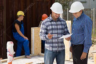 Engineer and architect discussing paperwork