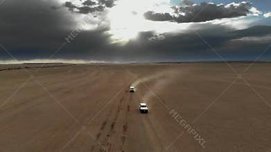 Offroad vehicles cross Gobi Desert dunes in Mongolia through remote sand country, desert convoy, sand dunes, dune crossing