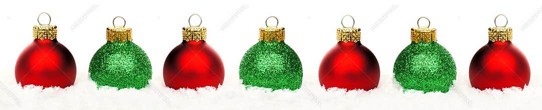 Christmas border of red and green baubles in snow isolated