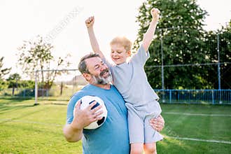 Dad and son sharing passion for football and active lifestyle.