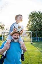 Dad and son sharing passion for football and active lifestyle.
