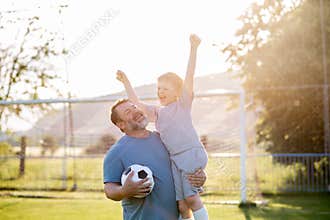 Dad and son sharing passion for football and active lifestyle.