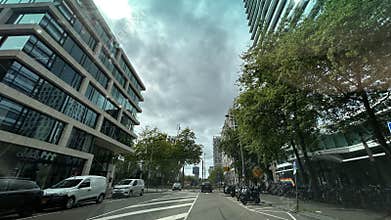 City street view with modern glass office building trees and cloudy sky
