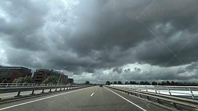 Amsterdam Zuida businessdistrict highway bridge under dramatic storm clouds with