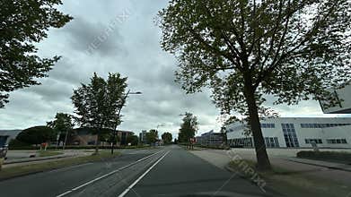 Tree lined business district road with modern office buildings, empty lanes