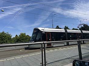 Modern tram at urban stop in Amsterdam Zuid with clear blue sky