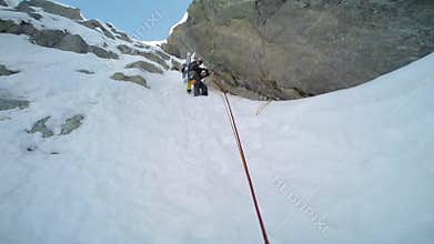 Ice climbing: mountaineer on a mixed route of snow and rock duri
