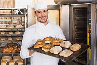 Happy baker showing tray of fresh bread