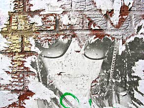 Faded poster on a brick wall