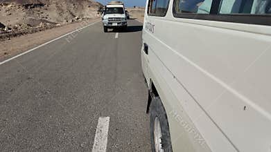Off-road vehicles driving in convoy through egyptian desert