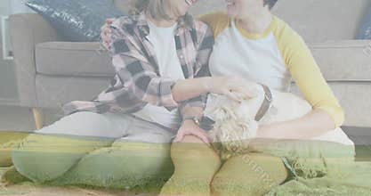 Sitting two women petting white dog on rug at home, wearing plaid-shirt, yellow-raglan, wristwatch
