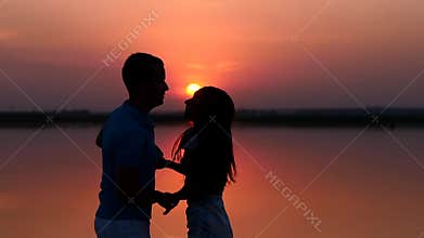 Silhouette man and woman dancing at sunset. Slow