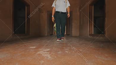 A woman standing in an ancient corridor