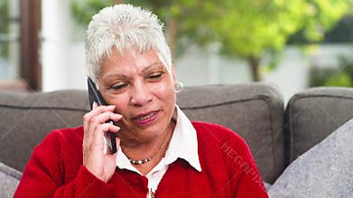 Happy Senior Woman Talking On Mobile Phone At Home