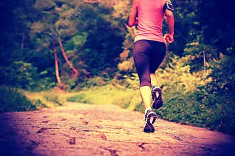 Woman runner running at forest trail