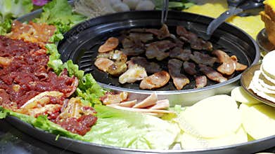 Korean BBQ Feast with Grilled Sausages, Marinated Beef, and Sliced Potatoes at a Seoul Street Food