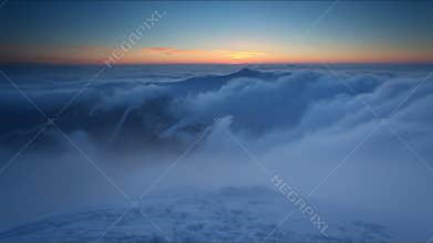 Winter mountain at sunset over clouds - time lapse video