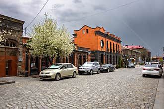 Urban street with vintage cars parked on stone pavement