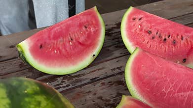 Juicy ripe watermelon divided into large slices and served on picnic plates during relaxed summer ????? in natural