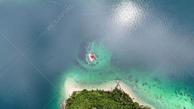 Bird-eye rotating shot of a small house on a shoal near the coast of Palawan, Philippines.