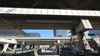 Urban overpass construction scene with modern office towers, roadway below