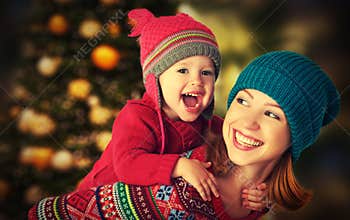 Happy family mother and little daughter playing in the winter for Christmas