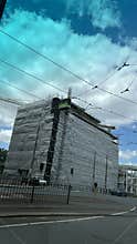 Modern office building and tram at urban street with blue sky and