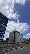 Modern office building and tram at urban street with blue sky and