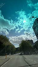 Urban street with highrise glass office building under dramatic cloudy sky