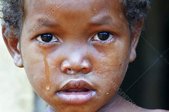 Crying girl with tear on cheek - poor african child