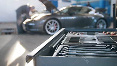 A set of tools for repair in car service in front luxury sport