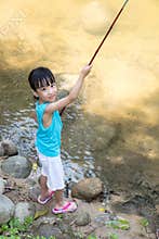 Happy Asian Chinese little girl angling with fishing rod
