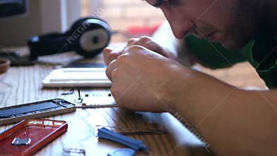 Master repairing broken phone, carefully collects fine details of the buyout are on the table. 3840x2160. 4k