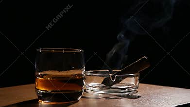 Whiskey drinks with smoking cigars